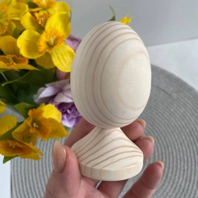 Деревянное яйцо на поставке для декора