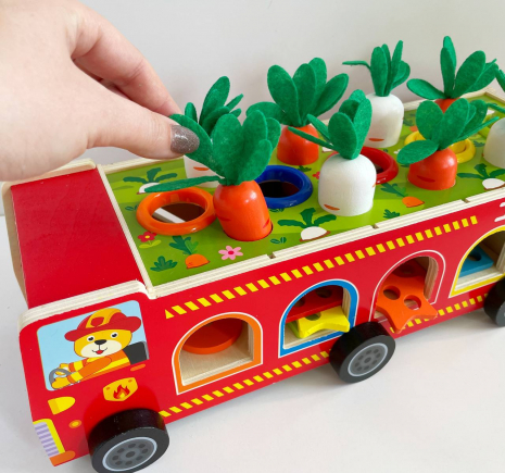 Дерев'яна багатофункціональна іграшка Пожежна машина (геометричний сортер, стукатка, грядка з морквинами), C 68271