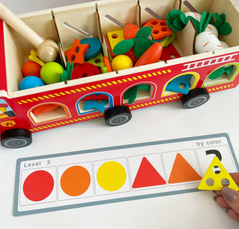 Дерев'яна багатофункціональна іграшка Пожежна машина (геометричний сортер, стукатка, грядка з морквинами), C 68271